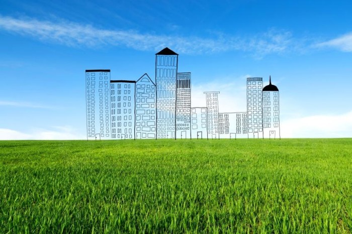 Concept of a new residential block in the new location. Buildings doodled on a real meadow